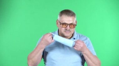 Kendini koronavirüs salgınından korumak için yaşlı bir adamın portresi yüzüne tıbbi bir maske takar..