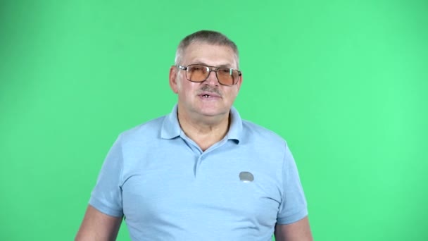 Portrait of aged man showing thumbs up, gesture like, isolated over green background. Stock Footage