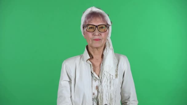 Portret van oude stijlvolle vrouw is strikt gebaren met de handen gekruist waardoor X vorm betekenis ontkenning zeggen NO geïsoleerd over groene achtergrond. — Stockvideo