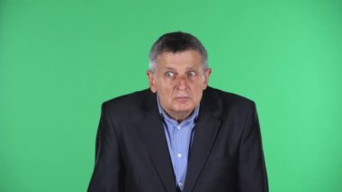 Yeşil arka planda izole edilmiş yaşlı bir adamın portresi çok şaşırtıcı..