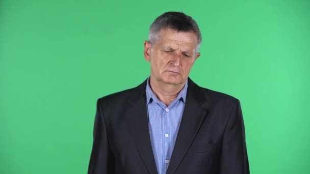 Portrait of aged man is upset isolated over green background. — Stock Video