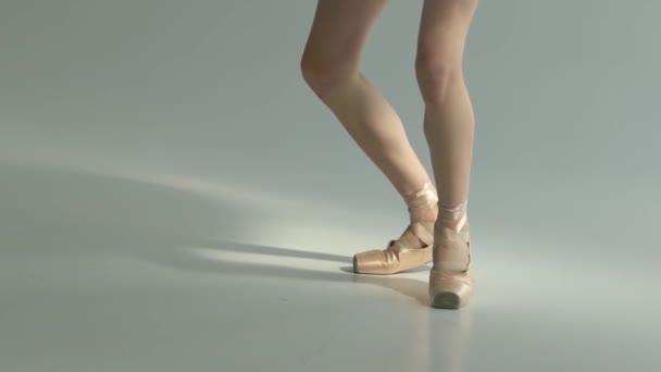 Slender balarina legs in pointe shoes perform pirouette movements. Fascinating dance. White background. Close up. Slow motion. — Stock Video