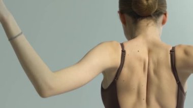 Klasik bale yapan genç bir balerinin narin sırtı. Dans stüdyosu dersi. Arkadan bak. Kapatın. Yavaş çekim.