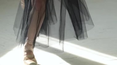 Genç ve yetenekli bir balerin parlak ışık huzmeleriyle piruet yapıyor. Bale stüdyosunda prova. Kapatın. Yavaş çekim.