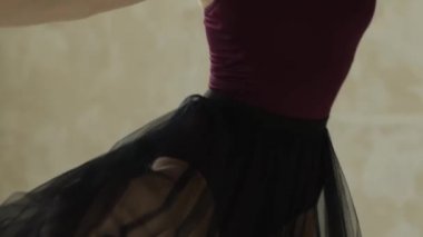 Siyah şeffaf etekli bir balerin dans ediyor. Klasik balenin büyüleyici akış hareketleri. Kapatın. Yavaş çekim.