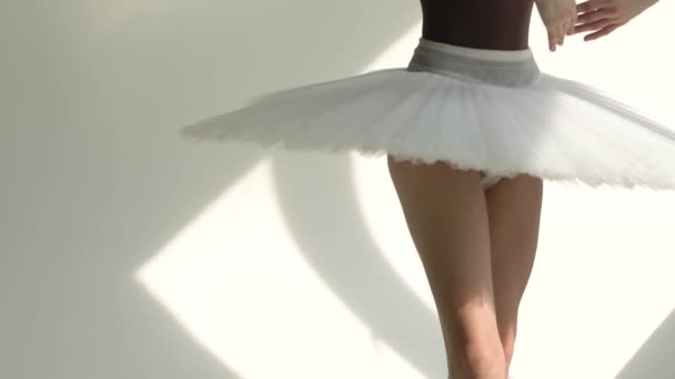 Danser i spidse sko på tæerne. Kvindelig danser laver balletøvelser. Dansestudie lektion. Skudt fra bund til top i et klart oplyst studie. Tæt på. Langsom bevægelse. – Stock-video