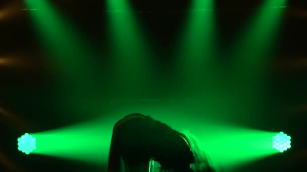 Sexy girl passionately dancing in dark studio with smoke and green neon lights. Silhouette attractive brunette in a sexy suit in the color of the English flag and rhinestones. Sexy female dance show. — Stock Video