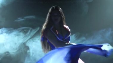Ateşli esmer, İngiliz bayrağı ve sahte elmaslarla seksi bir takım elbise içinde dans ediyor. Karanlık ve dinamik neon ışıklardaki gece kulübü. Dumanlı bir arka plan. Siluet. Kapat..