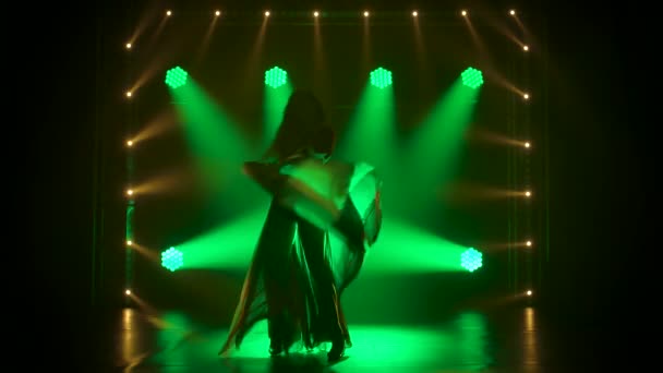 Slanke hoge vrouw hartstochtelijk dansen in donkere studio met rook en groene neon lichten. Silhouet aantrekkelijke brunette in een sexy pak in de kleur van de Engelse vlag en strass steentjes. Langzame beweging. — Stockvideo