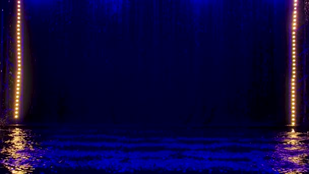 Blu schizza pioggia cadere contro sulla superficie dell'acqua che brillano. Fondo nero. Illuminazione al neon in uno studio buio. Rallentatore. — Video Stock