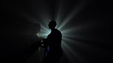Dans eden genç çift Latin müziği. Bachata, merengue, salsa. Arka planda neon ışıkları olan karanlık bir stüdyoda çekilmiş..