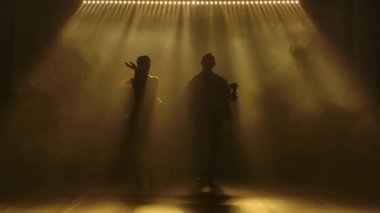 Dans eden genç çift Latin müziği. Bachata, merengue, salsa. Arka planda neon ışıkları olan karanlık bir stüdyoda çekilmiş..