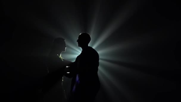 Giovane coppia che balla musica latina. Bachata, merengue, salsa. Girato in uno studio buio con luci al neon sullo sfondo. — Video Stock