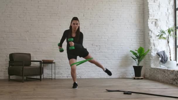 La jeune femme est engagée avec une bande élastique avant l'entraînement au hockey. Mouvement lent. — Video