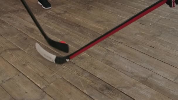 Hockey sticks hitting hockey red ball. Home practice floor hockey. A team game of two players. Slow motion. Close up. — Stock Video