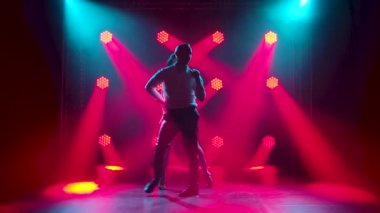 Dans eden genç çift Latin müziği. Bachata, merengue, salsa. Arka planda neon ışıkları olan karanlık bir stüdyoda çekilmiş..