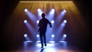Latin müziği yapan adam. Bachata, merengue, salsa. Arka planda neon ışıkları olan karanlık bir stüdyoda çekilmiş..