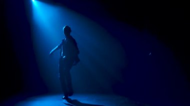 Latin müziği yapan adam. Bachata, merengue, salsa. Arka planda neon ışıkları olan karanlık bir stüdyoda çekilmiş..