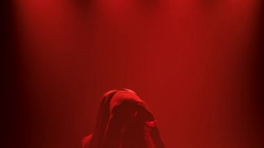 Spot ışıklarıyla modern dans eden bir kadın. Vogue ya da modern dans. Genç dansçı karanlık sahnede oynuyor..