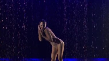 Yağmurda dans ederken zarif bir aktrisin silueti. Ağır çekim. Kapat..