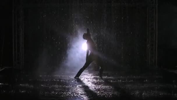 Sensual danza erótica contemporánea en el humo entre las gotas de lluvia. Un joven se mueve suavemente a lo largo de la superficie del agua, formando muchas salpicaduras. Coreografía de contemporáneos. Movimiento lento. — Vídeos de Stock