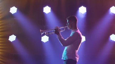 Sahnede trompetçi performansı. Trompet ellerde. Yan görüş. Yavaş çekim.