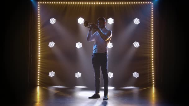 Solo performance of a professional trumpeter in the studio against the backdrop of neon lights. Slow motion. — Stock Video