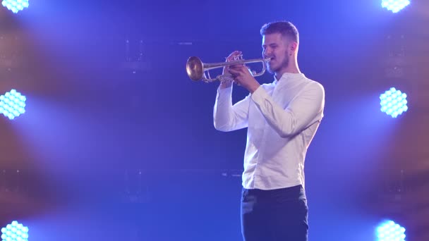 En man spelar entusiastiskt trumpet inomhus. Sakta i backarna. Närbild. — Stockvideo