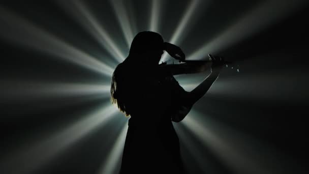 Vista inferior silueta negra de una mujer músico tocando el violín contra el fondo de luces dinámicas. En cámara lenta. De cerca.. — Vídeos de Stock