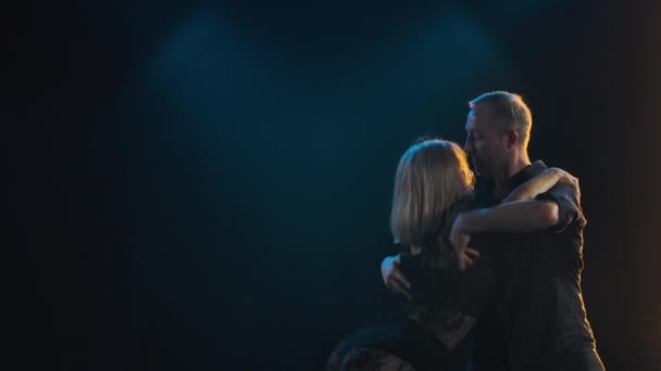 Leidenschaftliches verliebtes Paar übt Salsa-Tanz in einem dunklen Studio. Ein Mann und eine Frau tanzen begeistert auf schwarzem, rauchigen Hintergrund. Zeitlupe. Nahaufnahme. — Stockvideo