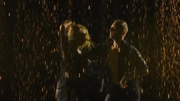 Позитивна доросла пара танцює сальсу в краплі дощу на чорному тлі. Повільний рух. крупним планом . — стокове відео