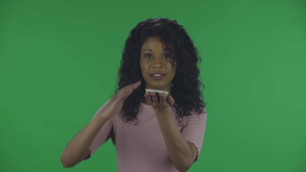 Portrait of beautiful african american young wealthy woman is scattering dollars with proud haughty expression, boasting rich life. Burning brunette with wavy hair in jeans and a beige blouse on a — Stock Video