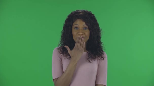 Portrét krásné africké americké mladé zmatené ženy se dívá na kameru a říká oops a pokrčení.Hořící bruneta s vlnitými vlasy v džínách a béžovou blůzu na zelené obrazovce ve studiu. — Stock video