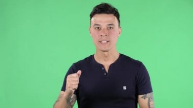 Yakışıklı bir gencin portresi kameraya heyecanla bakıyor ve zaferini kutluyor. Yeşil Ekran.