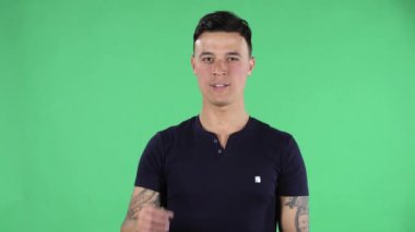 Yakışıklı bir gencin portresi kameraya bakıyor ve tabelayı düzeltiyor..