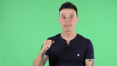 Yakışıklı bir gencin portresi kameraya heyecanla bakıyor ve zaferini kutluyor. Yeşil Ekran.