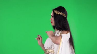 Yunan tanrısı elbisesi içindeki güzel kadın portresi ve yüksek çelenk modası düz görünüyor ve dans ediyor. Yeşil ekran. Yan görünüm.