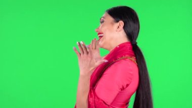 Ulusal klasik kırmızı sari giymiş genç bir Hintli kadının portresi mutlu ve neşeli bir ifade takınıyor. Yan görüş. Yeşil Ekran.