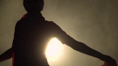 Siluet kırmızı sari giymiş genç bir kadın dansçı. Hint halk dansı. Karanlık bir stüdyoda duman ve neon ışıkla çekildi..