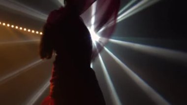 Siluet kırmızı sari giymiş genç bir kadın dansçı. Hint halk dansı. Duman ve neon ışıkla karanlık bir stüdyoda çekildi. Kapat..