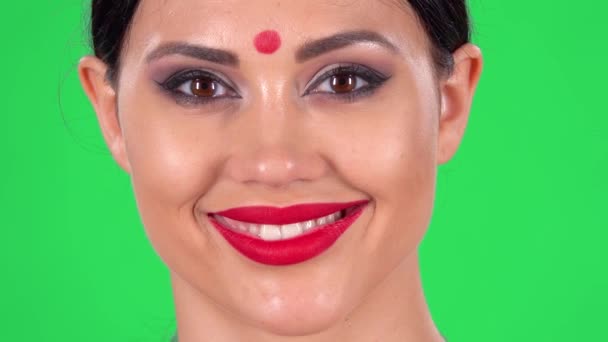 Портрет прекрасної індійської жінки серйозно дивиться на камеру, а потім посміхається. Зелений екран. Закрийся. Макро стрілянина. — стокове відео