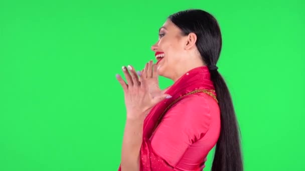 Portrait of a young Indian woman in national classic red sari is looking straight with very happy and joyful wow face expression. Side view. Green screen. — Stock Video