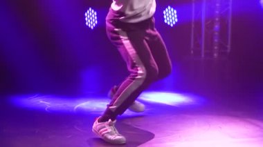 Breakdance 'in dinamik performansı, yenilikçi genç bir adamdan hip hop. Neon ışıkları altında sokak dansı. Kapatın. Yavaş çekim.