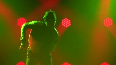 Yetenekli bir break dansçının silueti. Hip hop sokak dansı sahnenin önünde sahne ışıklarının önünde. Kapatın. Yavaş çekim.