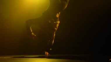 Yetenekli bir break dansçının silueti. Hip hop sokak dansı sahnenin önünde sahne ışıklarının önünde. Kapatın. Yavaş çekim.