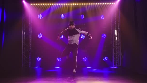 Эмоциональное выступление танцовщицы брейк-данса в темной студии с яркими динамичными неоновыми огнями. Концепция спортивного стиля. Медленное движение. — стоковое видео