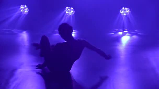 Profi balerina fekete karosszériában kecsesen táncoló balett dinamikus reflektorfényben és füst a színpadon. Silhouette egy gyönyörű karcsú alak. — Stock videók