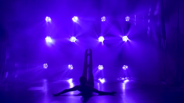 Profi balerina fekete karosszériában kecsesen táncoló balett dinamikus reflektorfényben és füst a színpadon. Egy gyönyörű karcsú alak sziluettje. Lassú mozgás.. — Stock videók