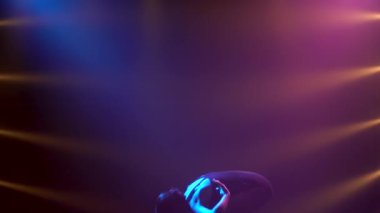 Siyah elbiseli profesyonel balerin zarif bir şekilde bale yapıyor. Dinamik spot ışıklarında ve sahnede dumanla çekilen. Güzel, ince bir siluetin silueti. Yavaş çekim.