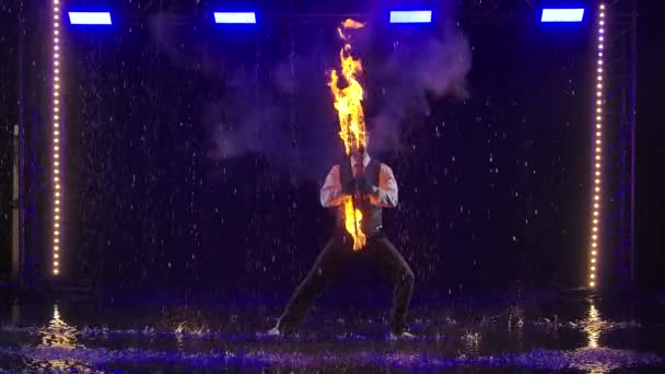 Vuurshow in de regen in de studio. Professionele kunstenaar voert een verscheidenheid van brandblusinstallaties in slow motion 's nachts. — Stockvideo